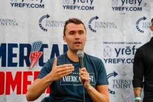 Turning Point USA founder Charlie Kirk speaks into a microphone during the American Comeback debate event on Greene Street on April 7, 2025. The event was part of Kirk's larger tour of various college campuses
